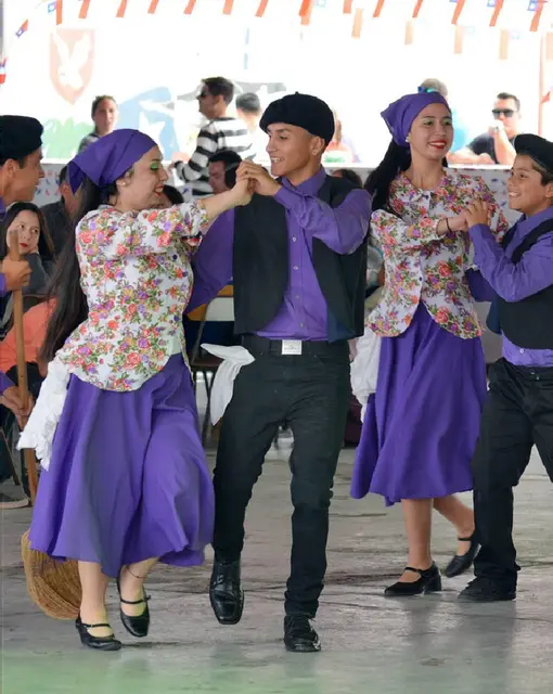 Parejas de Kahuira con vestuario chilote morado y floreado bailando en Iquique
